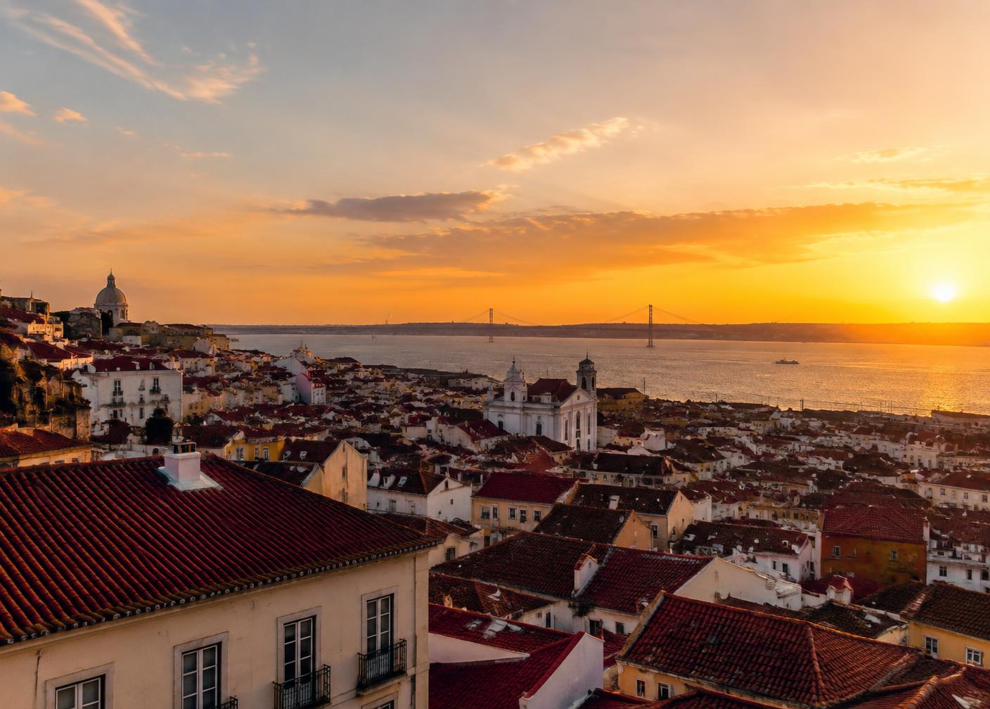 Lisbon rooftops and the Tagus river at sunset
