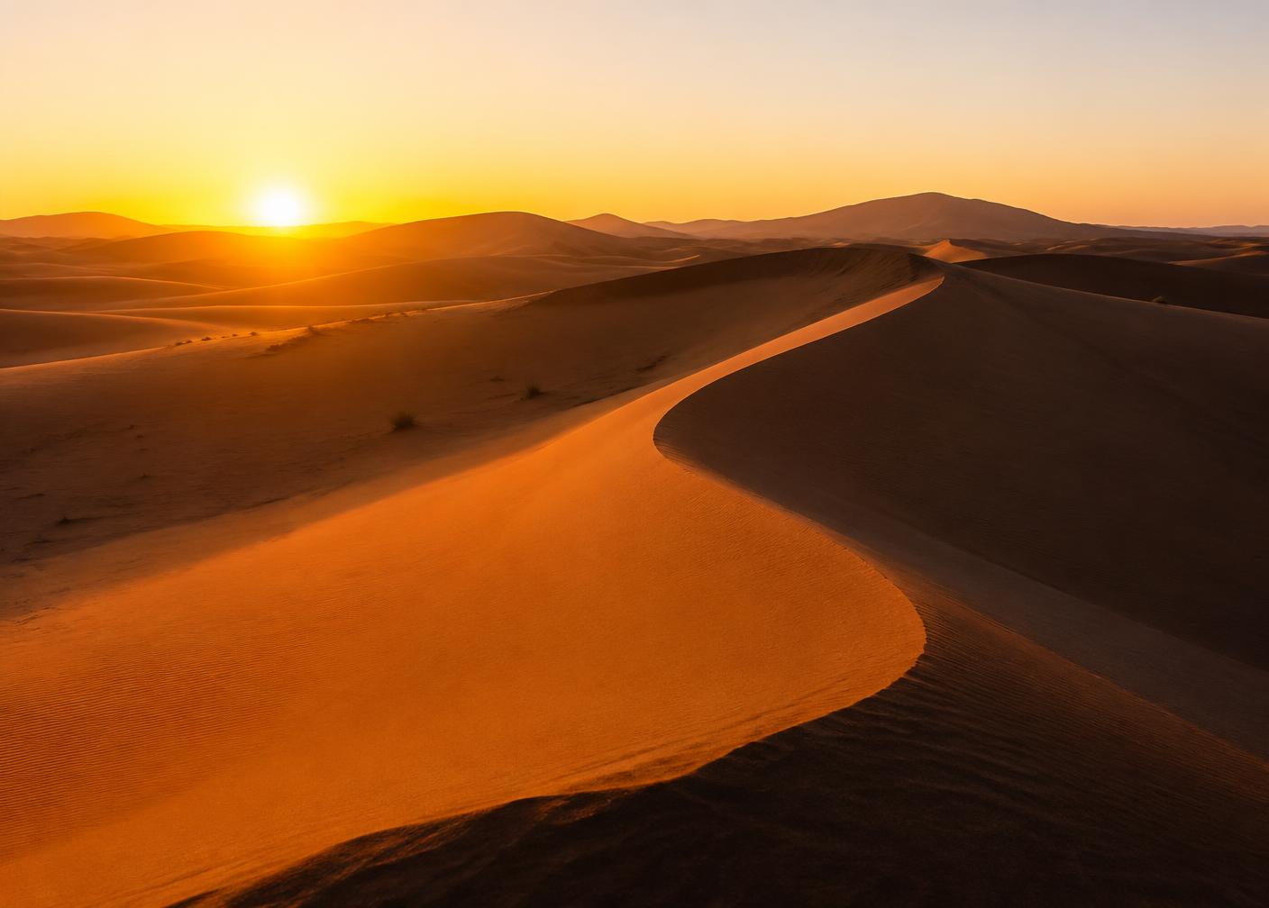 Sahara dunes glowing orange at sunrise