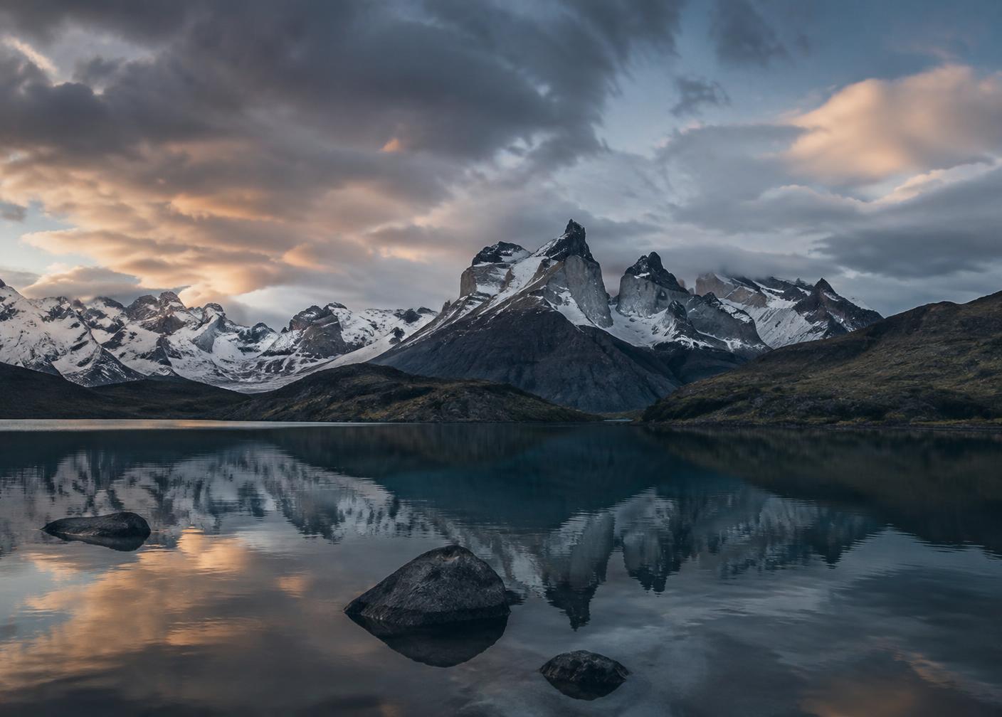 Snow-capped Patagonian peaks reflected in a still glacial lake at dawn